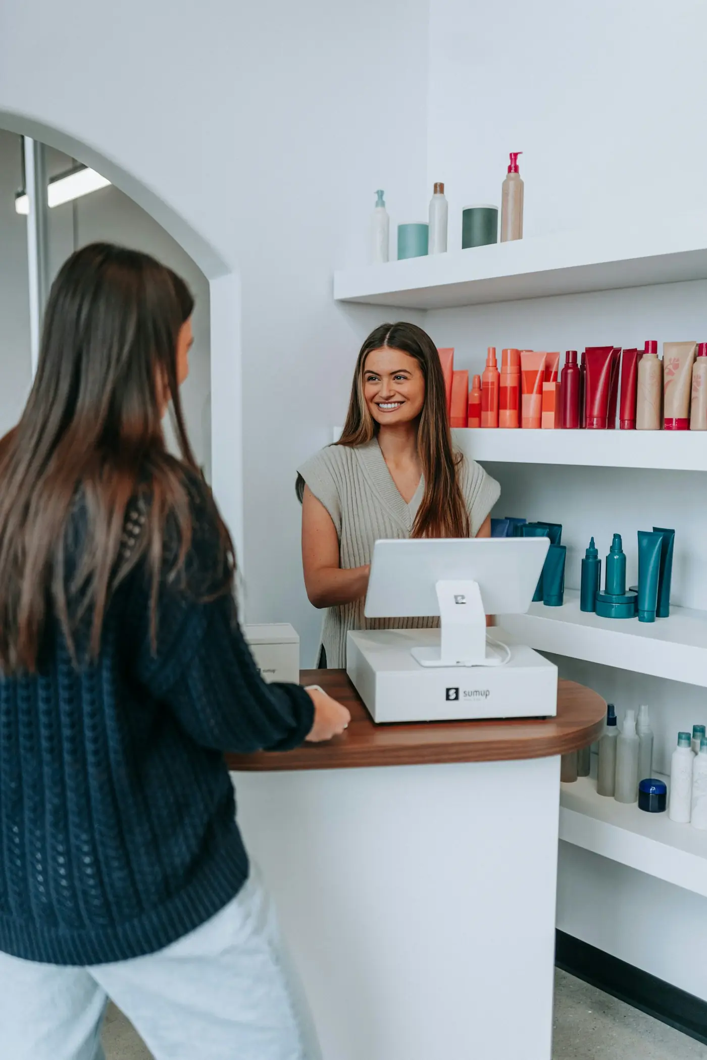 A client paying at a salon front desk