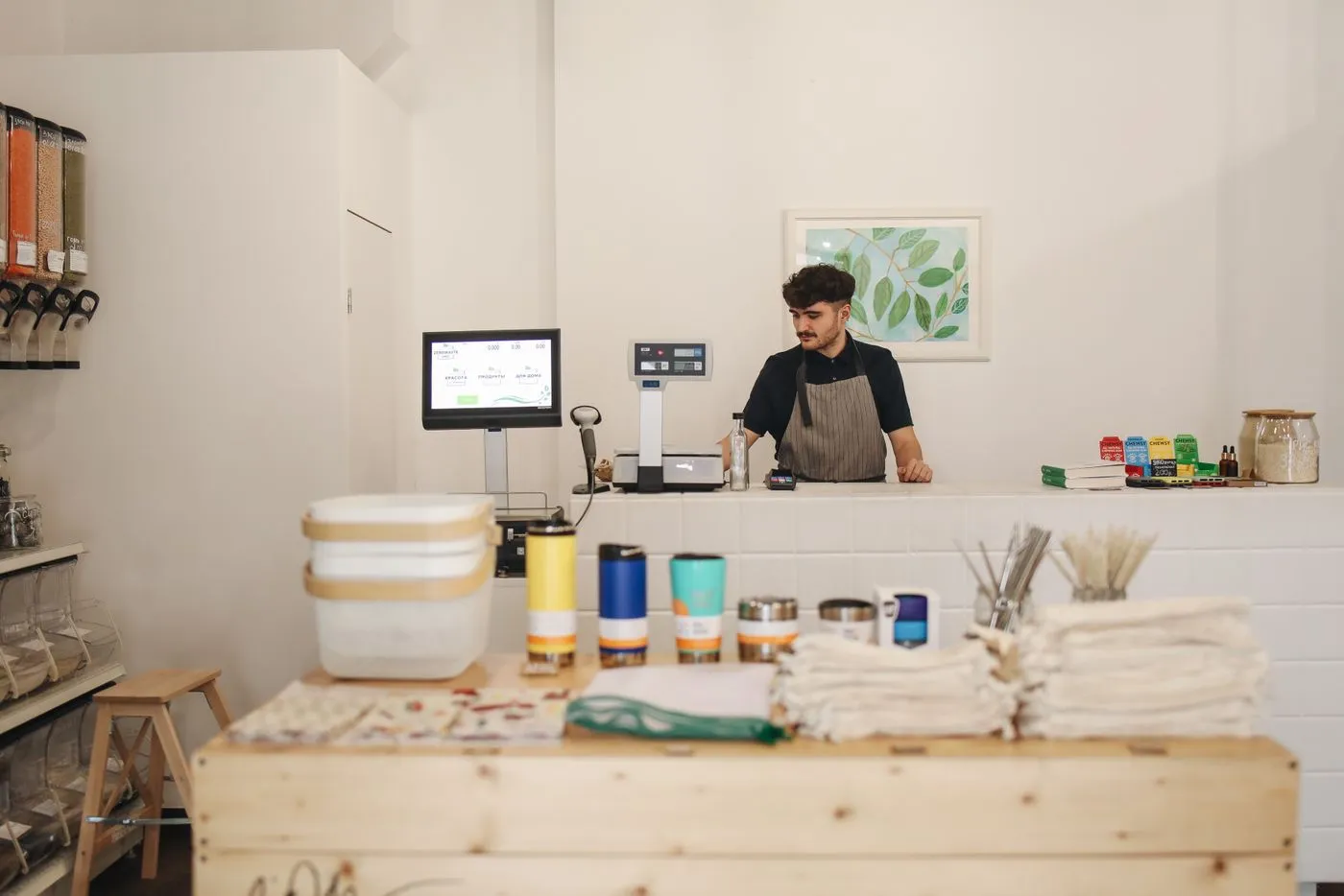 A shop owner behind the counter of his refill store